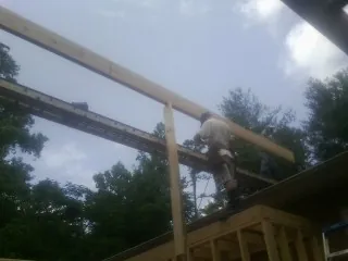 Carpenter setting a ridge beam over a new addition frame — Ice Dam Removal by Roofing Brothers in Inglewood